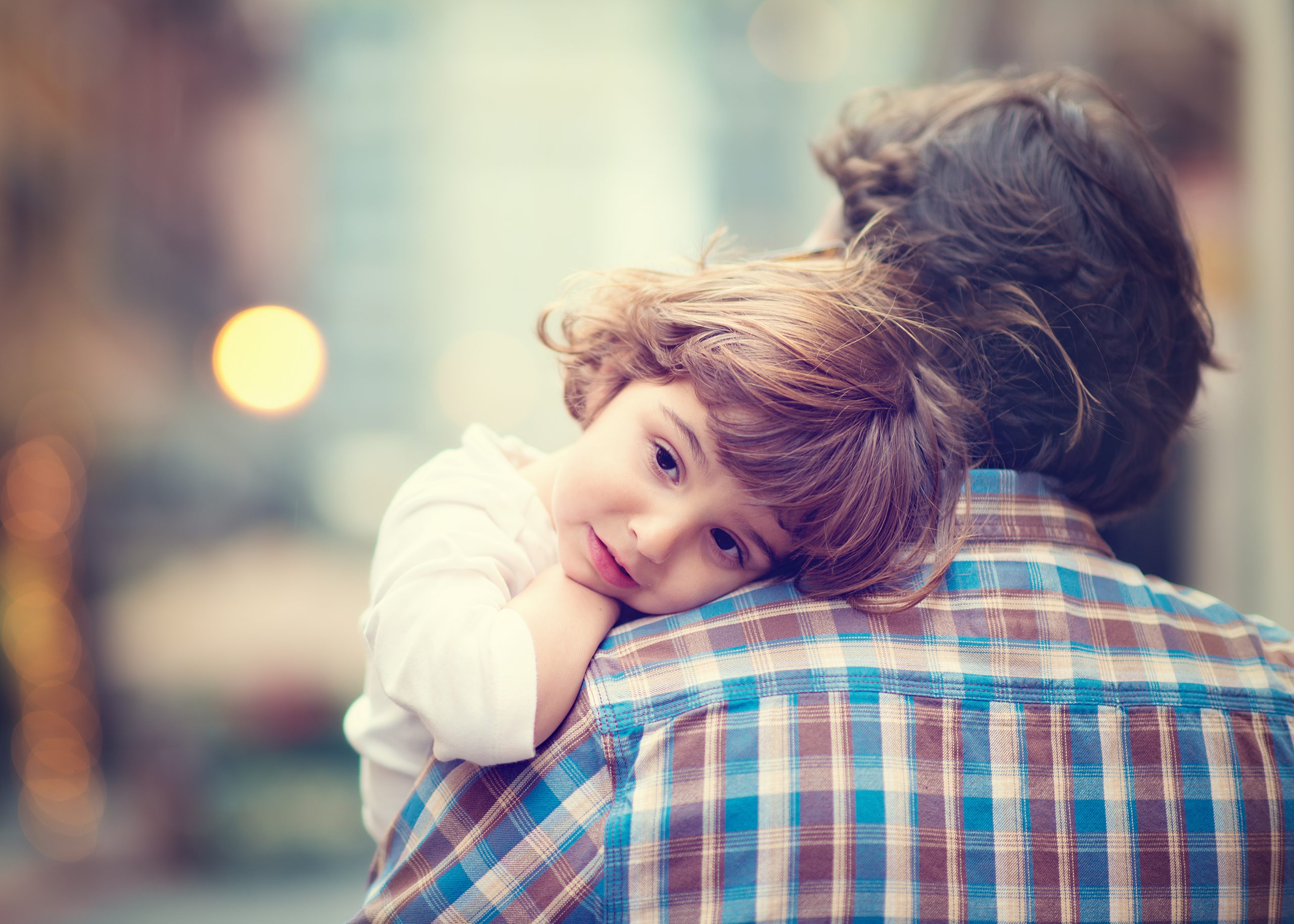 Little girl rests her head on her father's shoulder