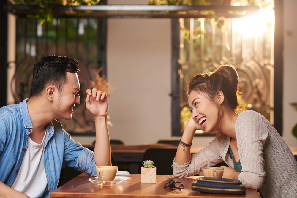 A couple laughs over coffee